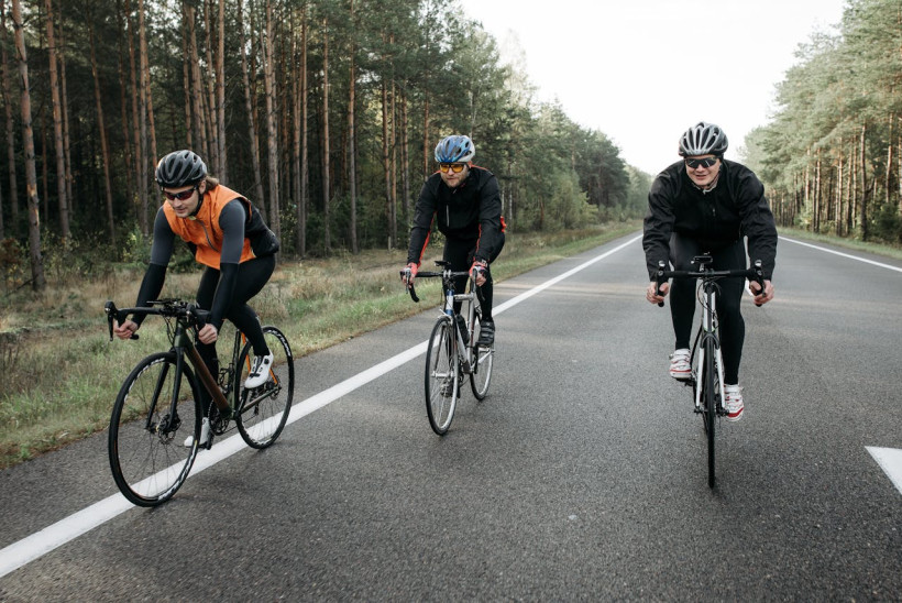 Radfahrer mit Helmen auf Waldstraße